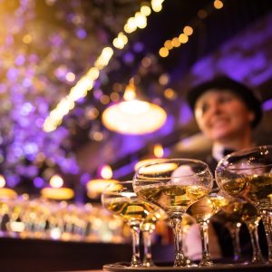 happy waitress holding a tray full of glasses or welcome drinks happy waitress holding a tray full of glasses or welcome drinks at an event